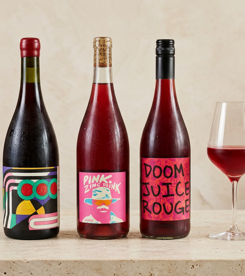 Parley Mood in Scarlet, Unico Zelo Pink Zinc Drink and Doom Juice Rouge bottles beside a glass of chilled red wine on a sunlit bar.